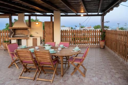 Serenity Stone House, a Blissful Retreat في Petrokefalo: طاولة وكراسي خشبية على الفناء