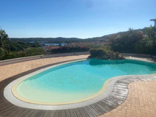una grande piscina in un cortile di mattoni di Residence Gli Oleandri 140 - Costa Smeralda - Porto Cervo a Liscia di Vacca