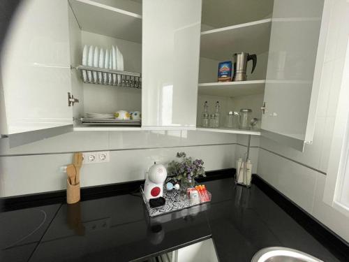 Una cocina blanca con fregadero y encimera. en Apartamento del Agua, en Rute