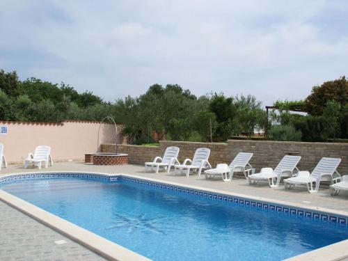 a swimming pool with lounge chairs and a swimming pool at Charming Apartment in Banjole near Sea in Banjole