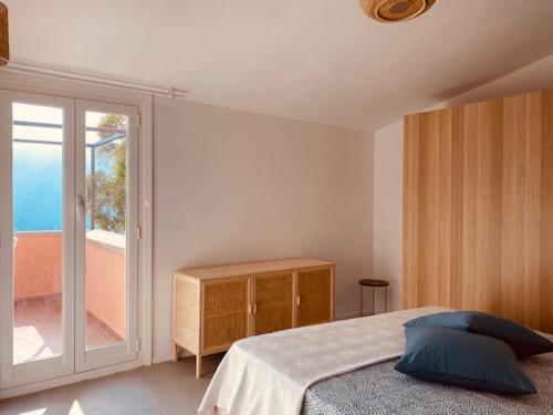 a bedroom with a bed and a sliding glass door at Casa la meridiana in Laigueglia