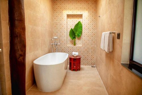 a bathroom with a large white tub in a room at Miraaya Wellness and Golf Resort in Chitwan