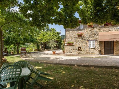 アッシジにあるHoliday Home in Assisi with Poolの芝生の中に緑のベンチが2つある石造りの建物