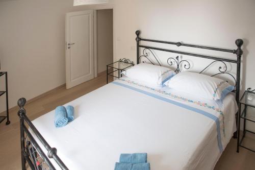 a bedroom with a bed with white sheets and blue towels at Ca' de Panaia in Lingueglietta