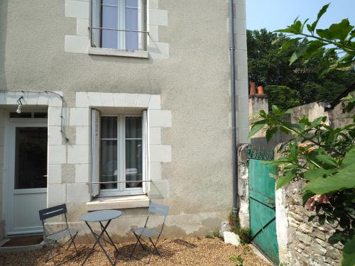 two chairs and a table in front of a house at L'Amboisienne, Au pays des châteaux in Amboise