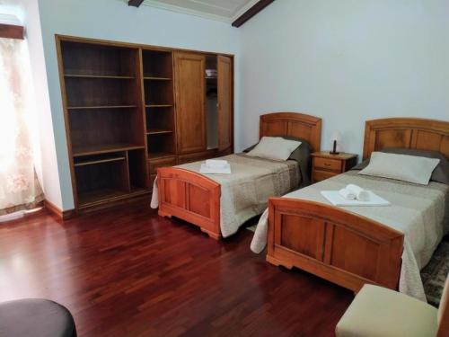 two beds in a room with wooden floors at Bettencourt 2 Rooms in Santa Cruz da Graciosa