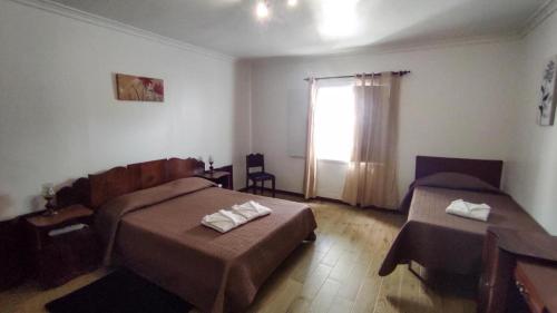 1 Schlafzimmer mit 2 Betten, einem Tisch und einem Fenster in der Unterkunft Bettencourt House in Santa Cruz da Graciosa