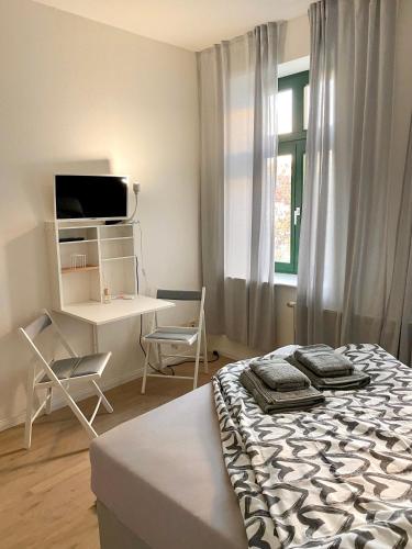 Schlafzimmer mit einem Bett, einem Schreibtisch und einem Fenster in der Unterkunft Studioapartment M15 im Plagwitzer Szeneviertel in Leipzig