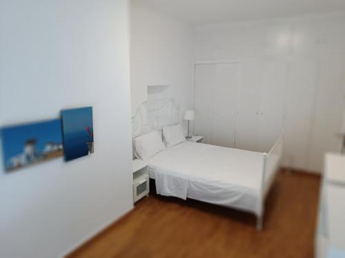 ein weißes Schlafzimmer mit einem weißen Bett und Holzböden in der Unterkunft 2 bedroom apartment near syntagma in Athen