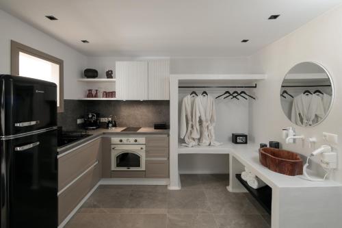 a kitchen with white cabinets and a black refrigerator at Annio studios in Plaka