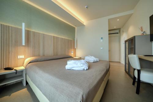 a hotel room with a bed and a desk and a sink at Hotel Palazzo del Garda & Spa in Desenzano del Garda