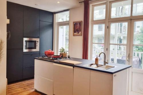 een keuken met een wastafel en een fornuis top oven bij Cozy apparment close to center with big terrace in Amsterdam