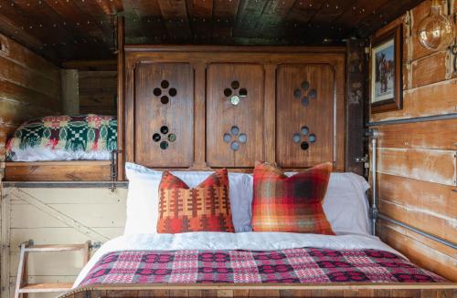 um quarto com uma cama com uma cabeceira e almofadas de madeira em Dennis em Goodwick