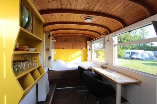 a dining room with a table in a tiny house at Tiny Pipowagen Koolmees in Oudesluis