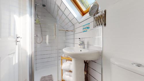 a white bathroom with a sink and a mirror at Beautiful Coach House in Gloucester