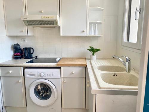 une cuisine avec une machine à laver et un évier dans l'établissement Studio à 100 m de la plage avec clim et balcon, à Nice
