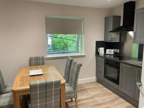 a kitchen with a table and chairs and a window at Inglewood House and Spa in Alloa