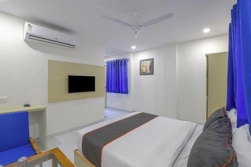 ein Schlafzimmer mit einem Bett und einem TV an der Wand in der Unterkunft Collection O Hotel La Veera in Ahmedabad