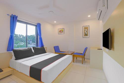 Schlafzimmer mit einem Bett, einem Schreibtisch und einem TV in der Unterkunft Collection O Hotel La Veera in Ahmedabad
