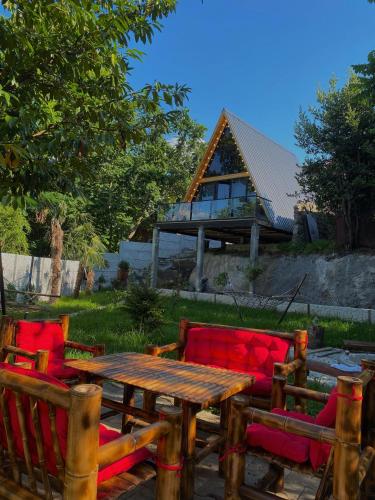 a wooden table and two chairs and a table and a house at Sun House in Batumi