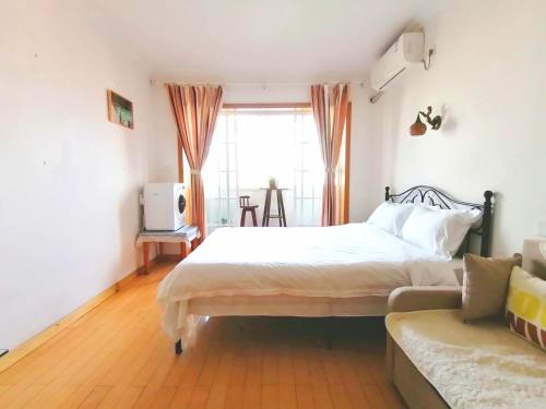 a bedroom with a bed and a couch and a window at Lily's home Jing'an Temple in Shanghai