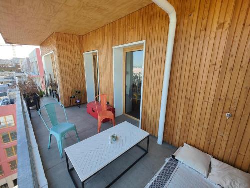 patio con mesa y sillas en el balcón en Relaxing Seine Views Apartment from Saint-Denis Island, en LʼÎle-Saint-Denis