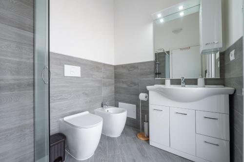 a bathroom with a sink and a toilet and a mirror at Casa Andrea in Assemini