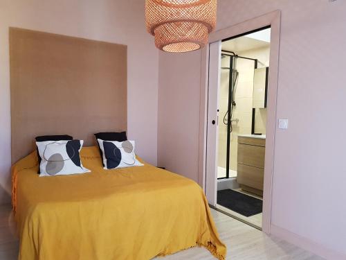 - une chambre avec un lit jaune et un miroir dans l'établissement La Poussinière, à Aiguèze