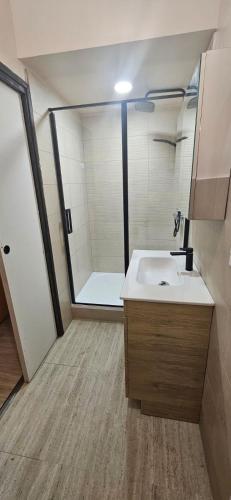 une salle de bain avec un lavabo blanc et une douche dans l'établissement La Poussinière, à Aiguèze