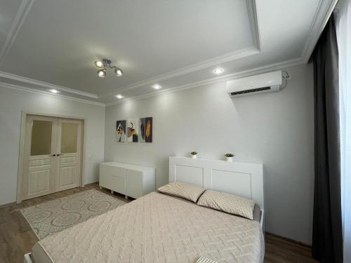 Un dormitorio blanco con una cama y una ventana. en Nova Center, en Astana