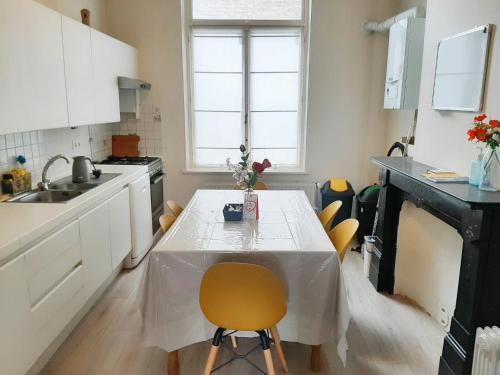 a kitchen with a table with a yellow chair at Superbe appartement au coeur du quartier européen in Brussels