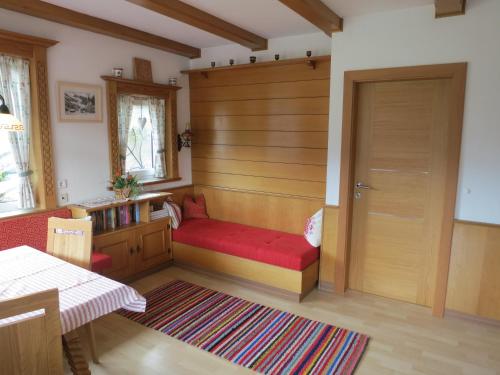 una habitación con un banco rojo y una puerta en Ferienwohnung Eller, en Telfes im Stubai