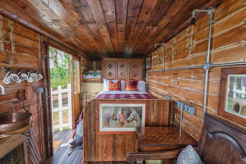 1 dormitorio con 1 cama en una cabaña de madera en Dennis, en Goodwick