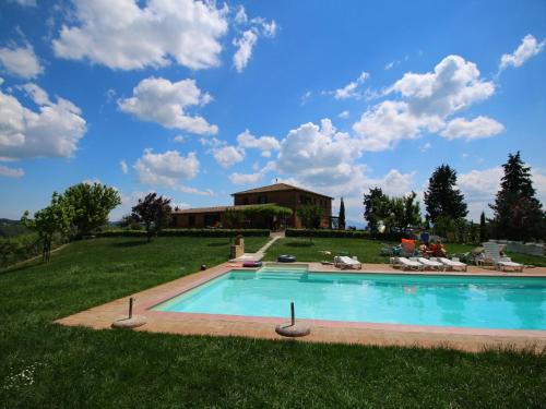 a swimming pool in a yard with a house in the background at 360 degree view over the Tuscan hills in Buonconvento