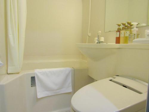 e bagno con servizi igienici bianchi e vasca. di Business Hotel Isesaki Heisei Inn a Isesaki
