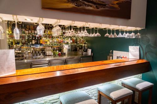 a bar with two stools in front of a counter at Hospitality Geraldton SureStay Collection by Best Western in Geraldton