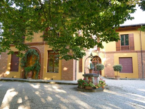 un edificio con un albero di fronte di Elegant Holiday Home in Faenza with Garden and Pool a Faenza