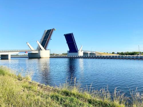 a bridge over a river with a bridge in the background at Villa Arkodes in Gdańsk