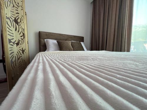 a bedroom with a white bed with a window at Luxury apartment Casa Al Mare in Rafailovici