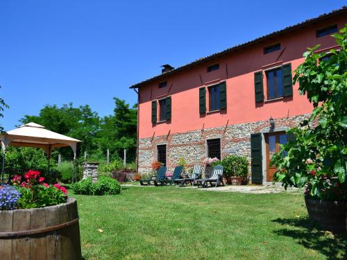 um edifício com um quintal com cadeiras e flores em Tuscan Farmhouse in Castiglione di Garfagnana with Garden em Castiglione di Garfagnana