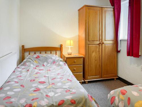 a bedroom with a bed and a dresser with a lamp at The Hereford - Uk44694 in Cheadle