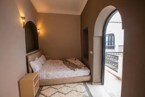 a small bedroom with a bed and an archway at Riad RIM in Marrakesh