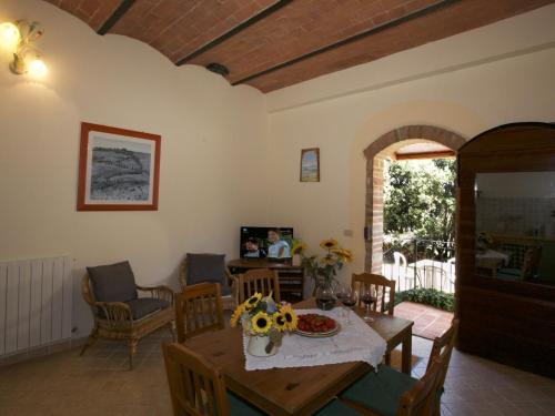 ein Wohnzimmer mit einem Tisch und Stühlen in der Unterkunft Lovely farmhouse in Tuscany with panoramic view in Castelnuovo Berardenga