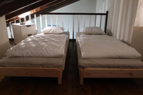 2 camas individuales en una habitación con escalera en Apartamento PinosPenthouse pie de pistas La Molina, en La Molina