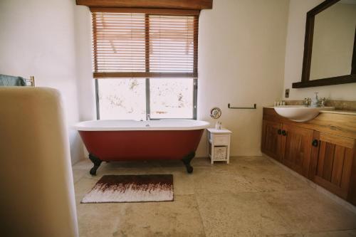łazienka z wanną, umywalką i oknem w obiekcie The River House Wanaka w mieście Wanaka