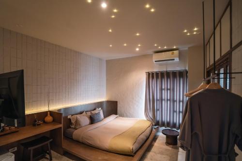 una camera da letto con un letto e una TV in una stanza di Muan Hotel a Chiang Mai