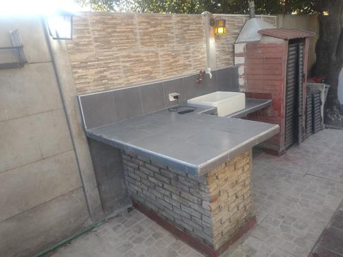 a bathroom with a sink and a brick wall at Cabaña para disfrutar en cualquier ocasión. in Burzaco