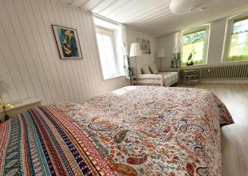 Un dormitorio con una cama con una manta de colores. en Cap Bonheur, 