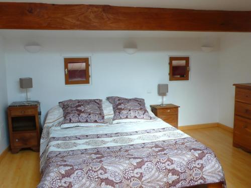 una camera con un grande letto e due comodini di Le Gîte ROUGE a Saujon