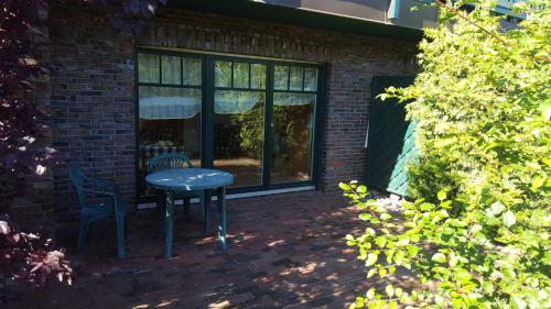 a patio with a table and chairs in front of a building at Urlaubslust Ferienhaus 16 in Trassenheide